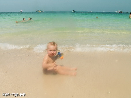 ребёнок учится плавать в море